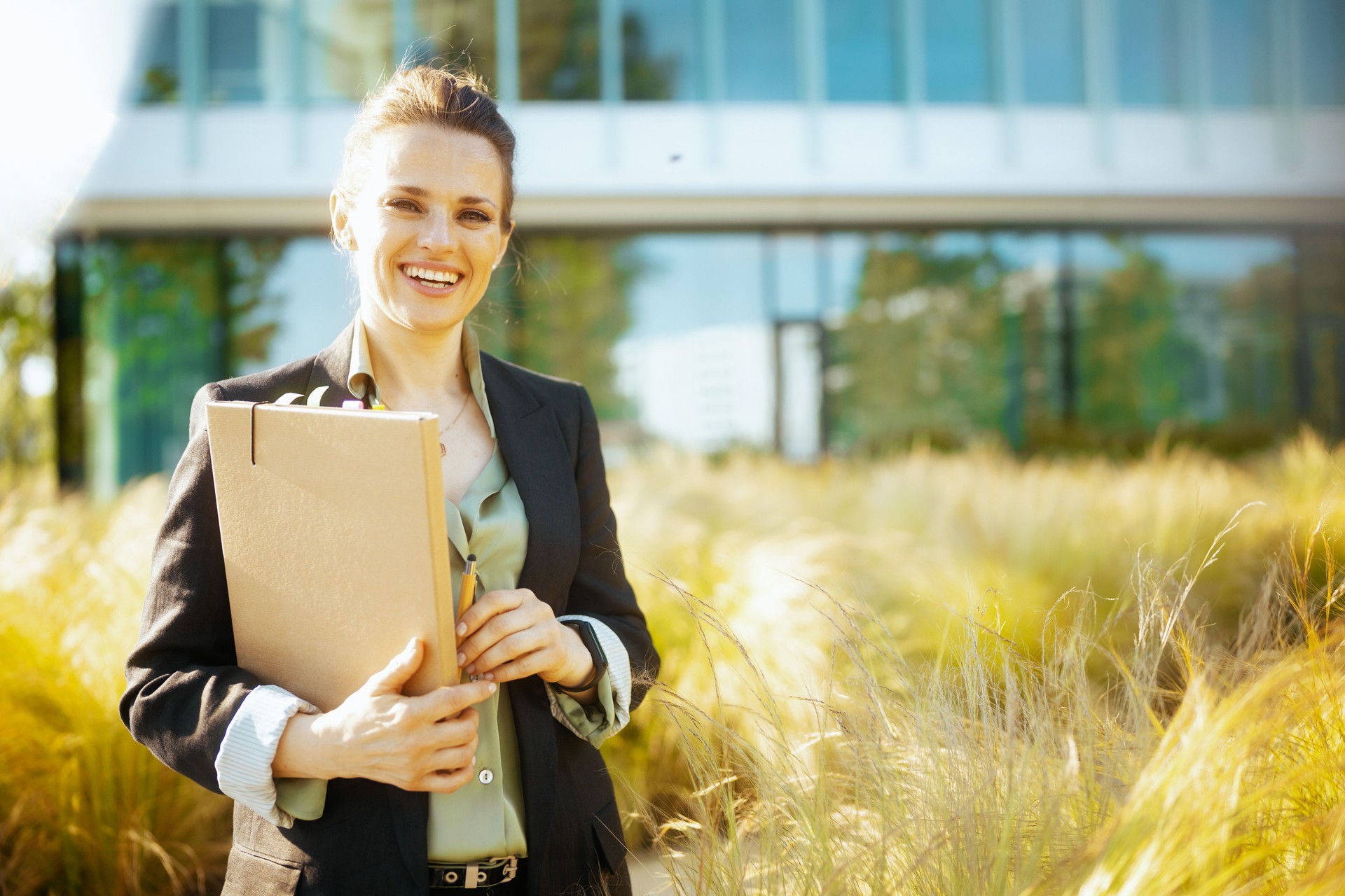 Portrait of happy business woman near office building